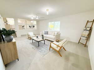 Living area featuring light colored carpet and a ceiling fan