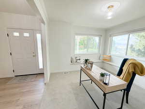 Foyer with ornamental molding and light wood finished floors