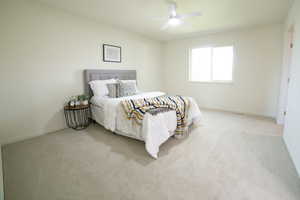 Carpeted bedroom with baseboards and a ceiling fan