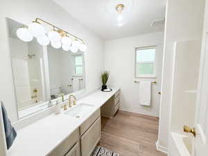 Full bathroom with shower / bath combination, vanity, and light wood-style floors