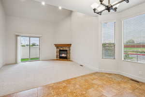 Spacious great room with vaulted ceiling, warm and inviting fireplace, and lots of natural light.