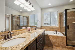 Primary en-suite Bathroom featuring a garden tub, double vanity, a stall shower, and recessed lighting