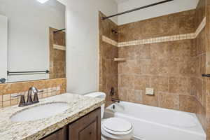 Main level Full bathroom featuring shower / bath combination and vanity with granite countertops.