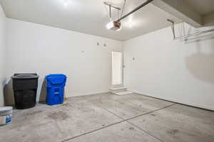 Garage featuring baseboards and a garage door opener