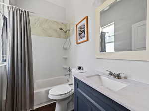 Bathroom with shower / tub combo with curtain, vanity, and dark wood finished floors