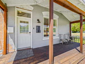 Entrance to property with brick siding and covered porch