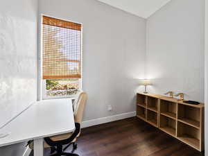Unfurnished office with baseboards and dark wood-style floors
