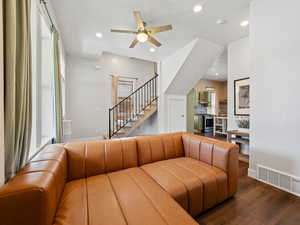 Living room featuring dark wood-type flooring, recessed lighting, a ceiling fan, and stairway