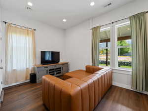 Living room with dark wood-type flooring and recessed lighting