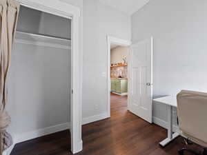 Home office with baseboards and dark wood-style flooring