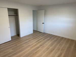 Unfurnished bedroom featuring light wood-style flooring and a closet