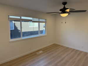 Unfurnished room featuring light wood-type flooring and a ceiling fan