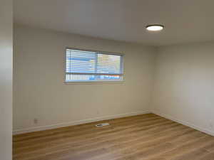 Unfurnished room featuring light wood-type flooring and baseboards