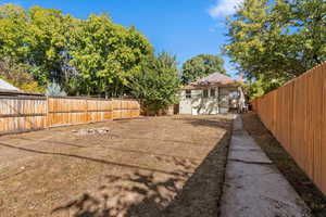 Fenced backyard featuring an outdoor structure