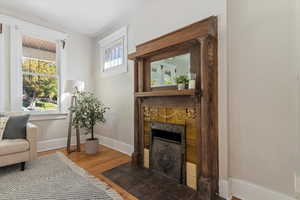 Sitting room with wood finished floors and a tiled fireplace