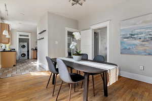 Dining area with light wood finished floors and stacked washer / dryer