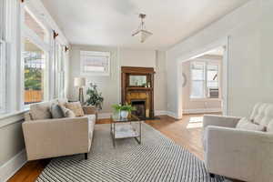 Sitting room featuring light wood-type flooring, a fireplace, and cooling unit