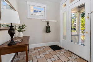 Doorway to outside featuring baseboards and stone finish floors