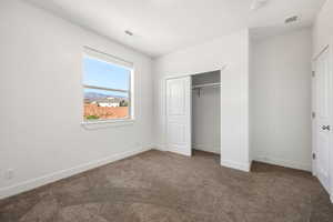 Unfurnished bedroom with carpet flooring and a closet