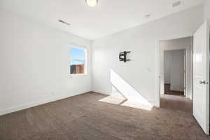 Carpeted empty room featuring baseboards