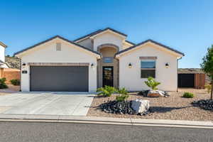 View of front of home with driveway, an attached garage, and stucco siding