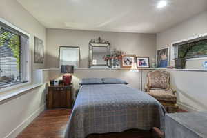 Bedroom featuring dark wood-type flooring and baseboards