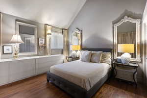 Bedroom featuring dark wood finished floors and high vaulted ceiling