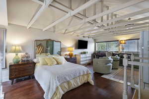 Bedroom featuring wood finished floors and freestanding refrigerator