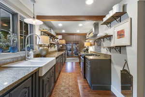 Kitchen featuring open shelves, light stone countertops, dark wood finished floors, black range with gas stovetop, and recessed lighting
