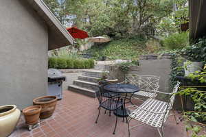 View of patio with a grill and outdoor dining area