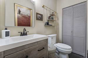Bathroom featuring vanity, dark tile patterned flooring, and a closet