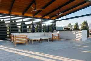 View of covered patio with a ceiling fan and an outdoor kitchen hangout area