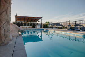 View of MASSIVE 20'x40' swimming pool with a covered patio w/ outdoor kitchen
