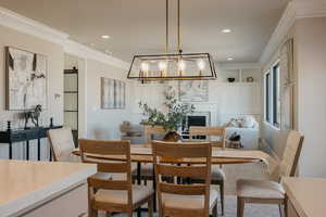 Dining space with crown molding, wood finished floors, a fireplace, built in features, and recessed lighting
