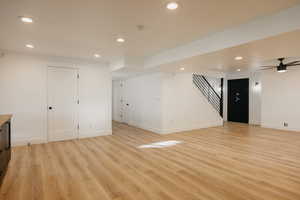 Basement family room with recessed lighting, light wood-type flooring, gun/storage safe, full kitchen, custom woodwork and ceiling fan.  Access to bedroom #4 and full bathroom.  Walkout Basement