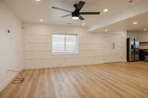 Unfurnished family room featuring ceiling fan, light wood-style flooring, a decorative wall, and recessed lighting