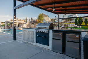 View of patio with an outdoor kitchen and a ceiling fan