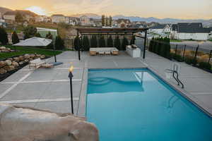 Pool at dusk featuring a 270 degree views!  Tiki Torches and so much space to entertain with the covered deck and outdoor kitchen!