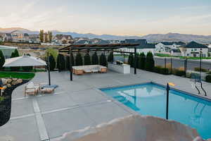 View of covered patio with outdoor kitchen, swimming pool featuring a massive Grotto with Slide & Waterfall.  Pool features a diving board & built-in basketball hoop!