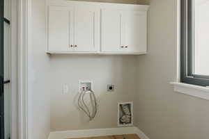 Laundry area featuring washer hookup, light wood-style floors, hookup for an electric dryer, and cabinet space