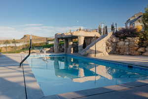 View of 20'X40' pool with built-in basketball hoop, a Grotto that has a WATERFALL, CLIFF JUMPING and SLIDE!