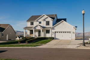 View of front of home with board and batten siding, covered porch, a mountain view, concrete driveway, and a shingled roof