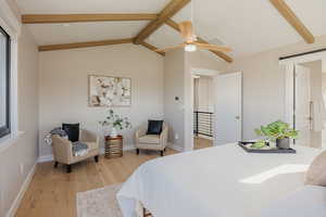 Primary Bedroom with sitting area, light wood-style flooring, a ceiling fan, and ensuite bath