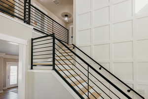 Staircase with crown molding & custom woodwork and custom rod iron contemporary railings