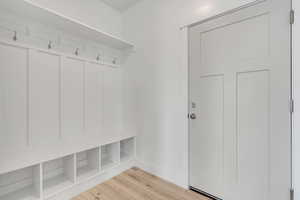 Mudroom with light wood-type flooring and baseboards