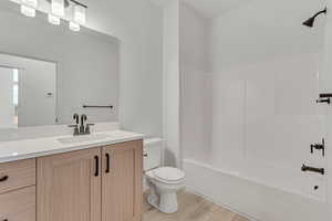 Full bathroom with vanity, tub / shower combination, and light wood-style floors
