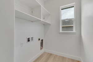 Laundry room with light wood-style flooring, hookup for an electric dryer, and hookup for a washing machine