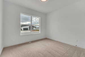 Carpeted spare room with baseboards