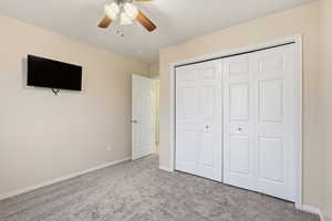Unfurnished bedroom featuring carpet, ceiling fan, and a closet
