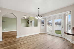 Unfurnished dining area with baseboards and light wood finished floors